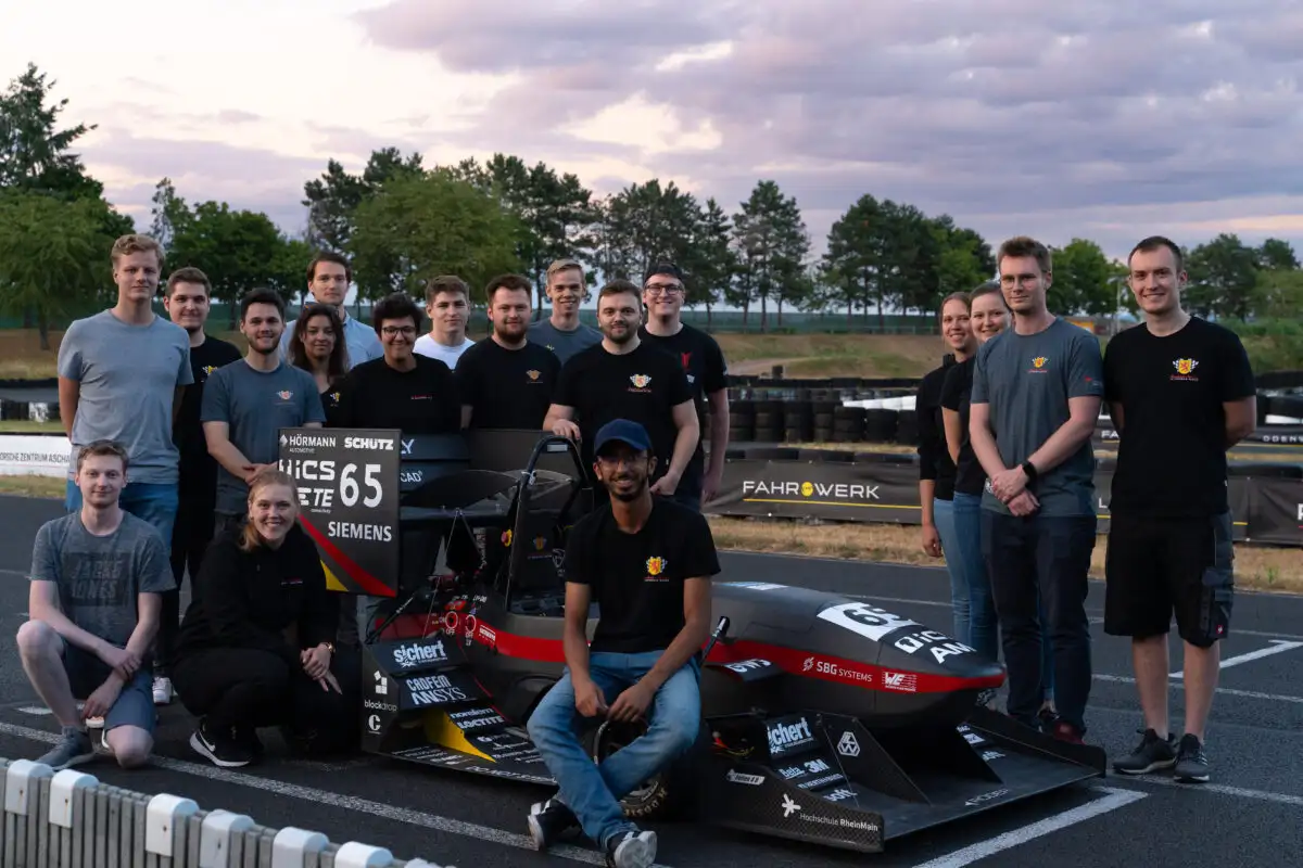 Eine Gruppe Alumni und Scuderia Mensa Teammitglieder vor dem Formelwagen SPR21evo.